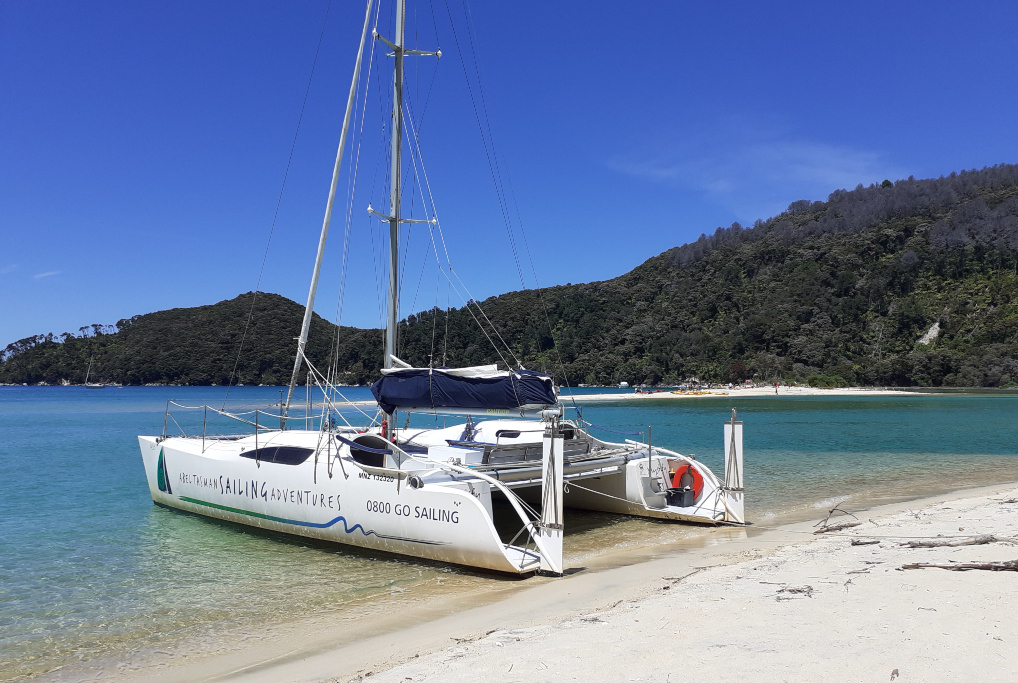 Abel Tasman Sailing Adventures katamaran anchored on the beach