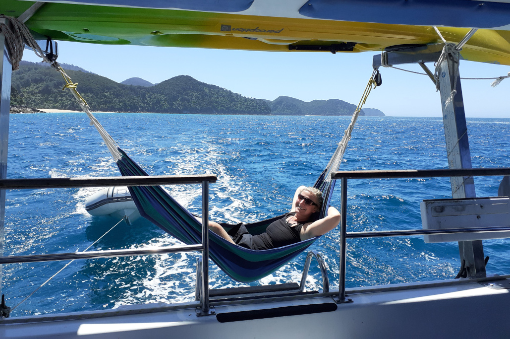 woman relaxing in a hammock on sailing boat